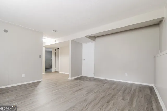 a view of an empty room with wooden floor