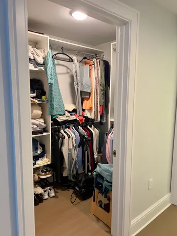 a view of walk in closet with clothes and shoes