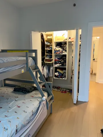 a bedroom with a bed and a flat tv screen on the dresser