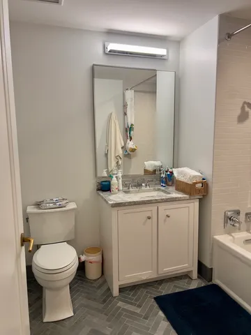 a bathroom with a toilet a sink and mirror