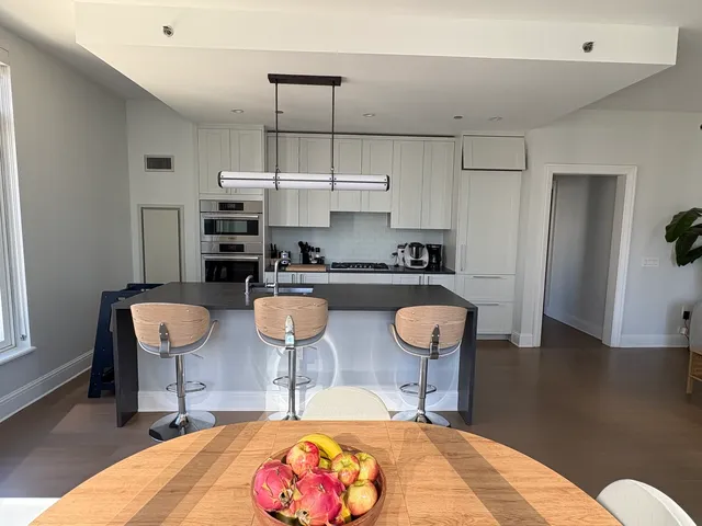 a kitchen with stainless steel appliances kitchen island granite countertop a table and chairs