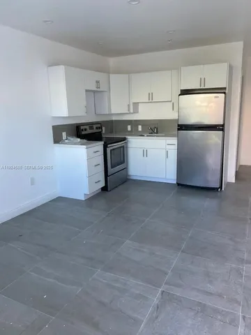 a kitchen with stainless steel appliances granite countertop a refrigerator sink and cabinets