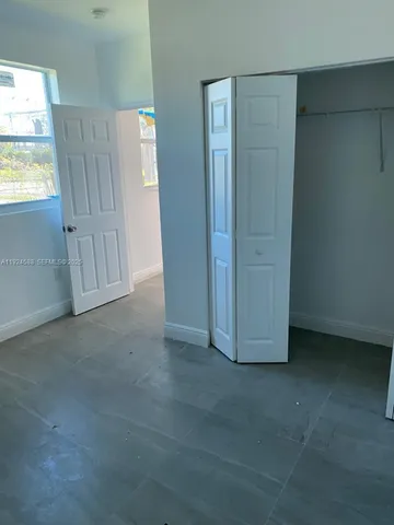 an empty room with windows and closet