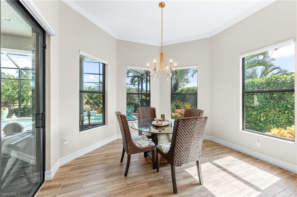 6818 Canwick Cove Circle Naples, FL 34113 - Photo 11 of 44 Dining space featuring light wood-style floors, crown molding, and suspended lighting