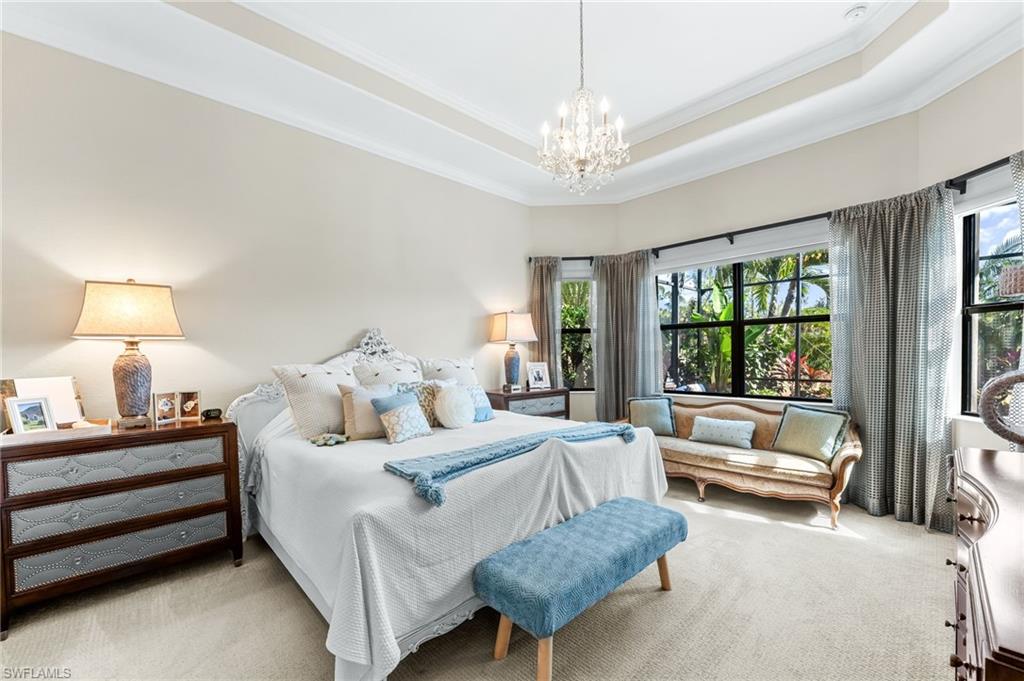 6818 Canwick Cove Circle Naples, FL 34113 - Photo 12 of 44 Carpeted bedroom featuring suspended lighting, a tray ceiling, and crown molding