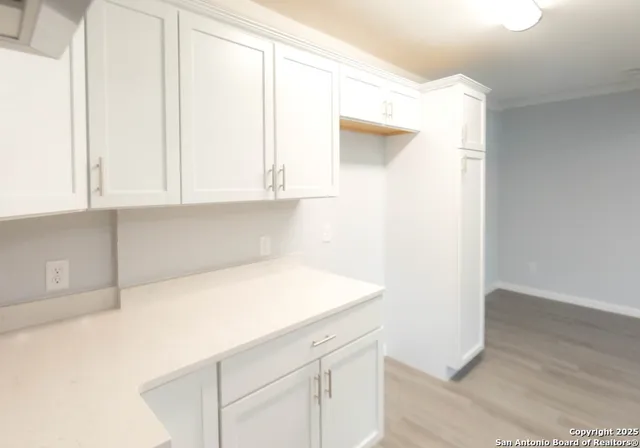 a view of an empty room with wooden floor and closet