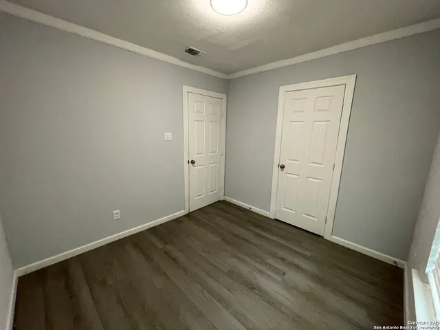 a view of an empty room with wooden floor