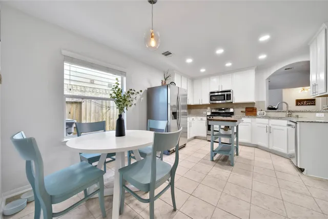 a kitchen with kitchen island granite countertop appliances cabinets and dining table