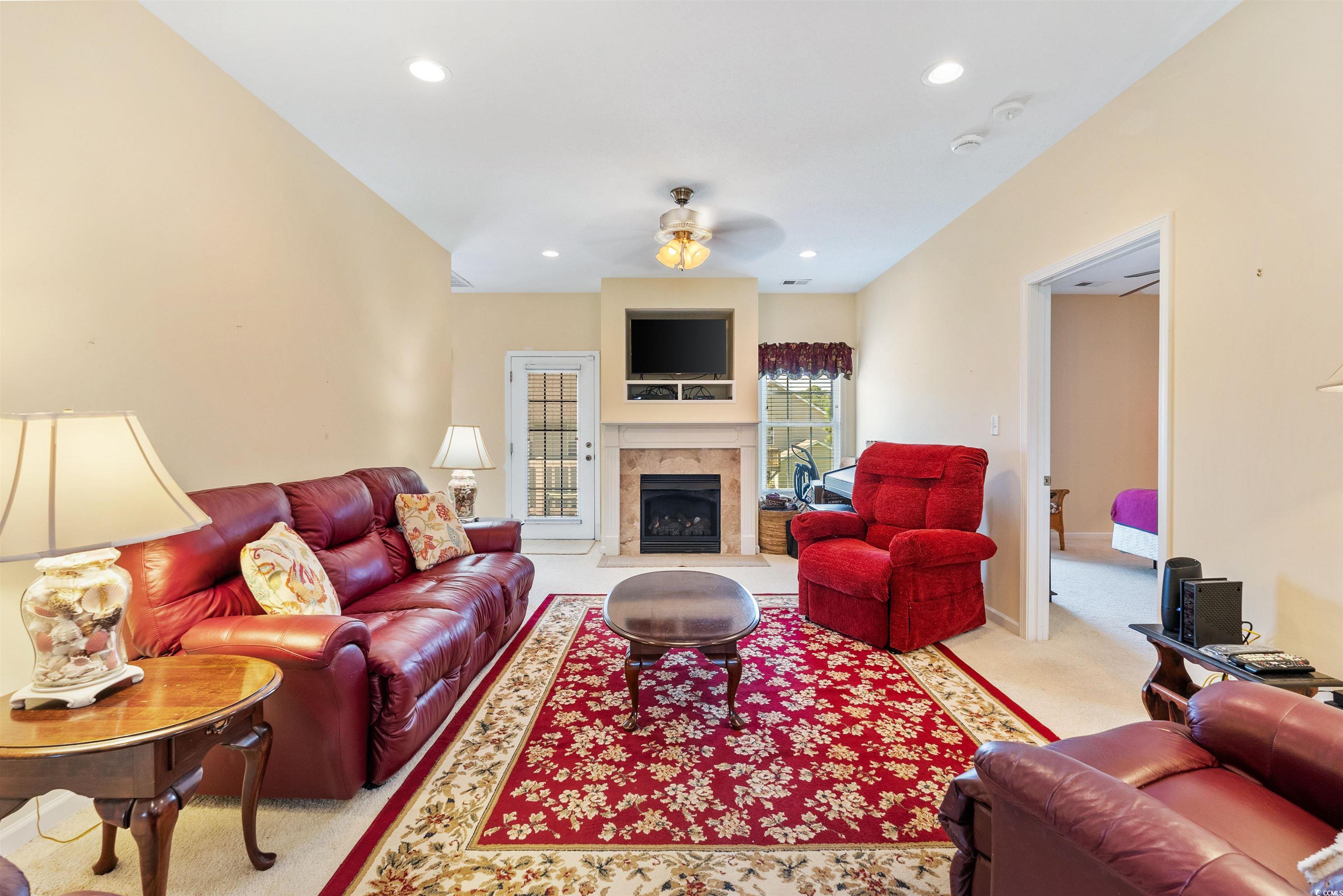 513 Rainbow Drive Murrells Inlet, SC 29576 - Photo 4 of 29 Carpeted living room with ceiling fan and a firepl