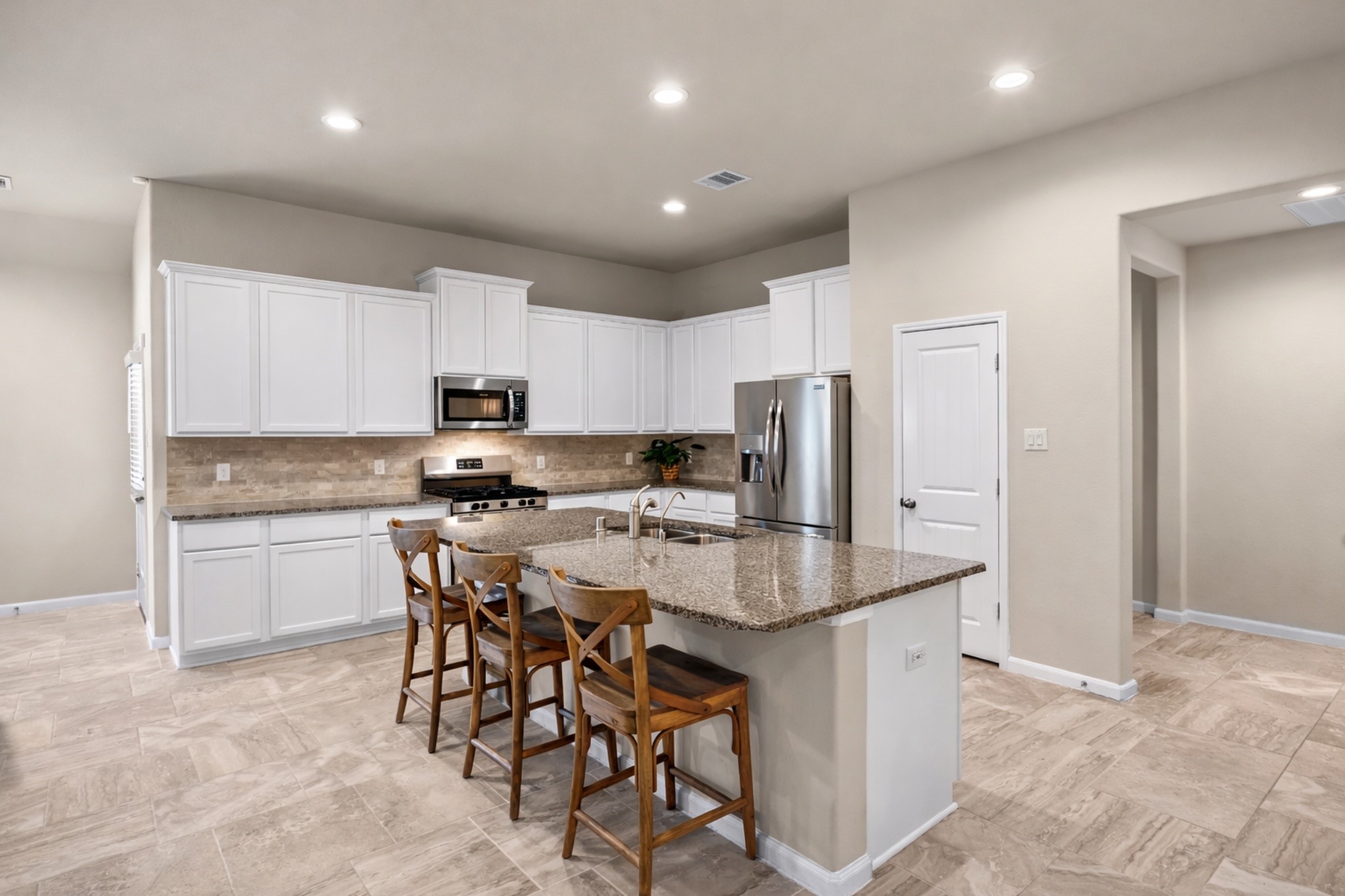 519 Yellow Bullhead Court Rosenberg, TX 77469 - Photo 8 of 24 a kitchen with stainless steel appliances granite countertop a sink a stove a refrigerator with a dining table and chairs