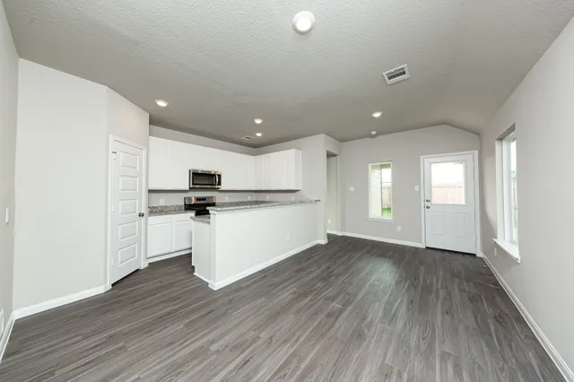 a kitchen with a refrigerator and white cabinets