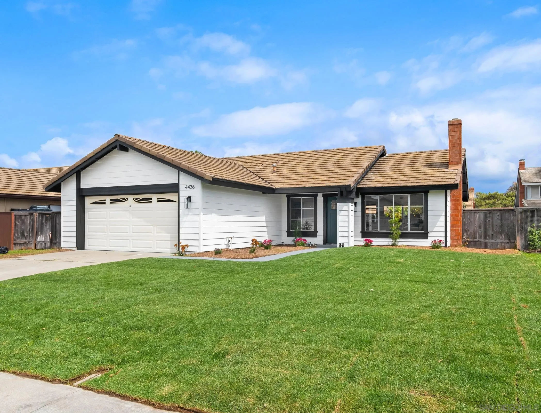 a view of a house with a yard and pathway