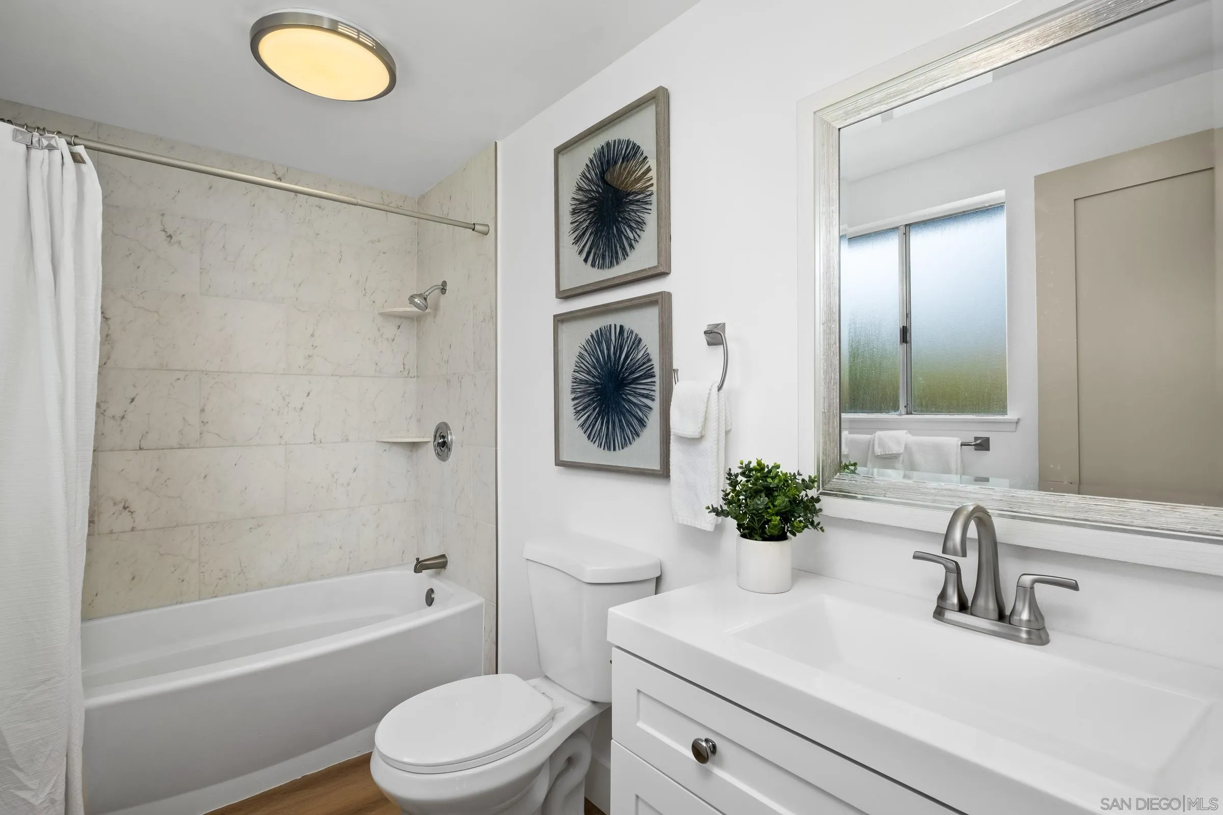 4436 Point Vicente Oceanside, CA 92058 - Photo 14 of 23 a bathroom with a sink a mirror a bathtub and shower
