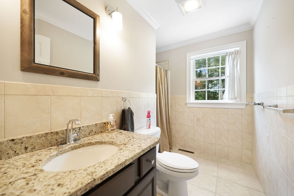 489 Main Street Acushnet, MA 02743 - Photo 23 of 37 a bathroom with a granite countertop toilet a sink and a mirror