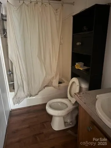 a bathroom with a toilet and a shower curtain