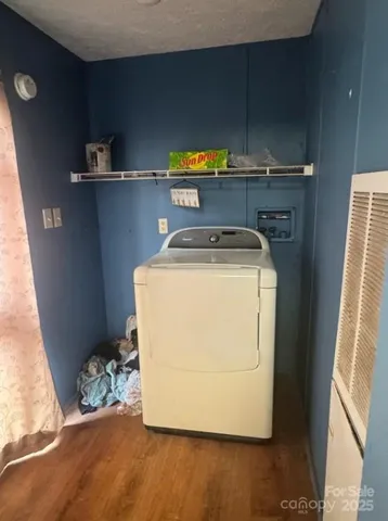 a utility room with wooden floor washer and dryer