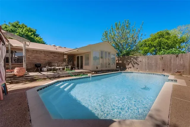 a view of a backyard with potted plants and a large tree