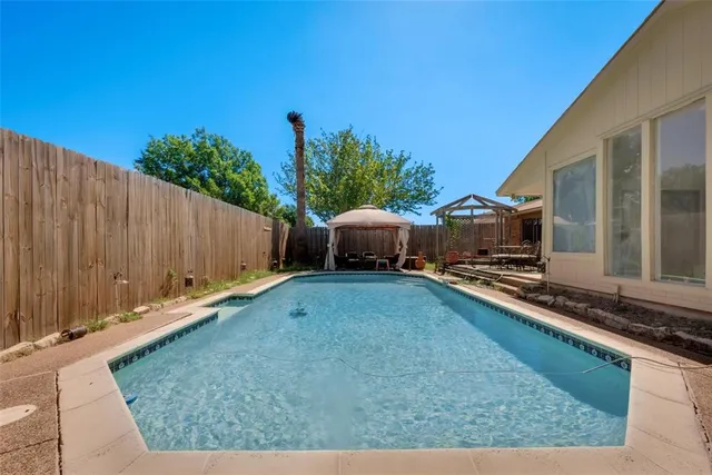 a backyard with a table and chairs and potted plants