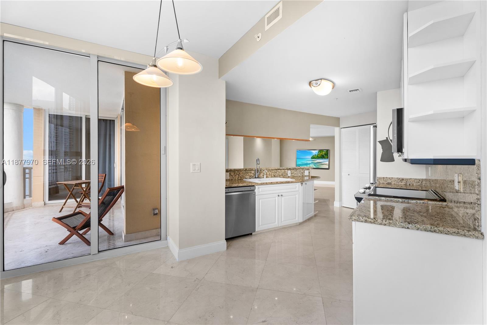 848 Brickell Key Drive, Unit 2502 Miami, FL 33131 - Photo 11 of 40 a kitchen with white cabinets and white appliances
