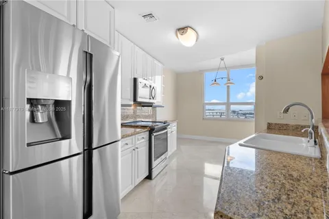 a kitchen with white cabinets and white appliances