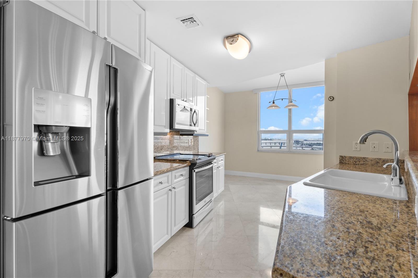848 Brickell Key Drive, Unit 2502 Miami, FL 33131 - Photo 16 of 40 a large kitchen with stainless steel appliances granite countertop a refrigerator and a sink