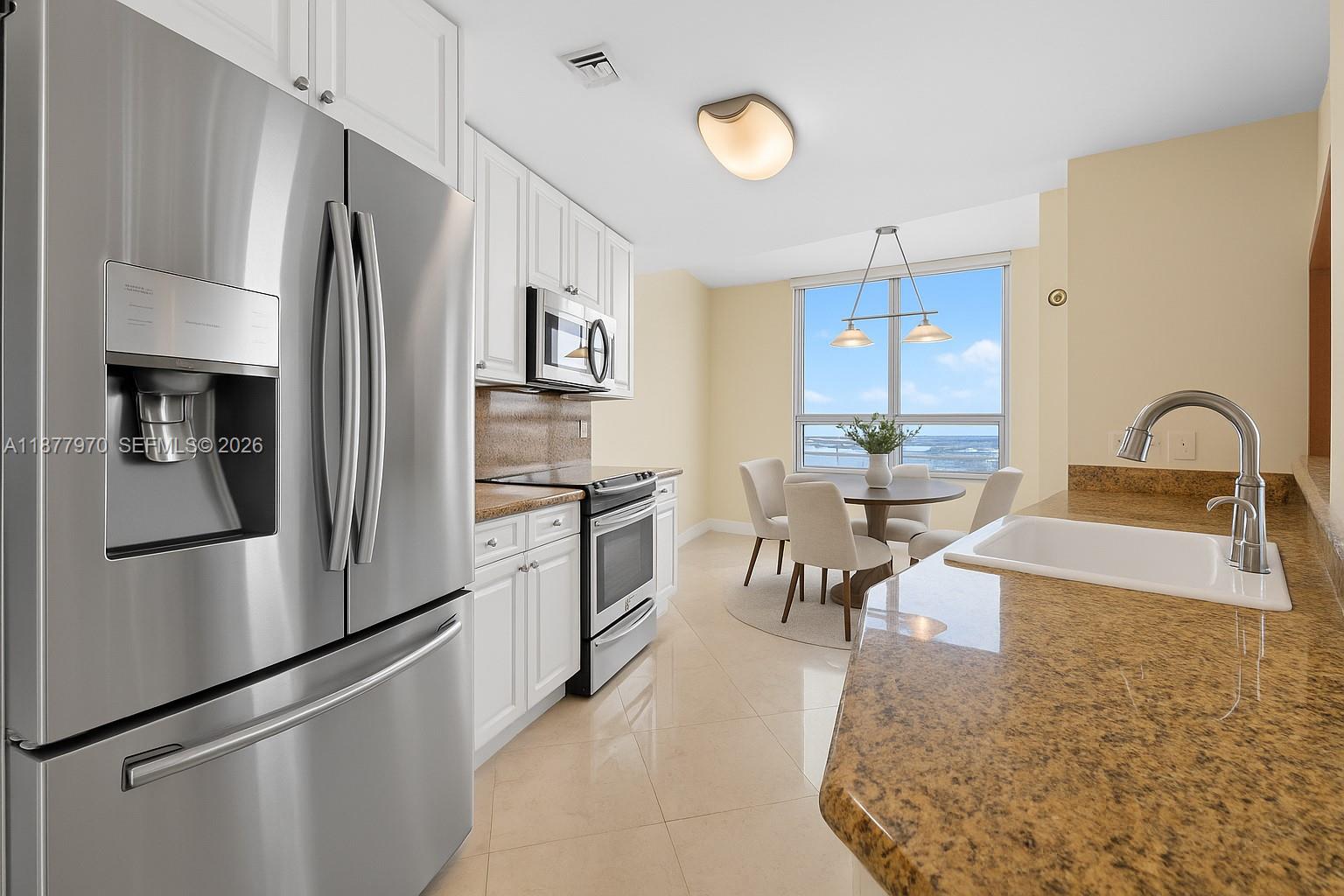 848 Brickell Key Drive, Unit 2502 Miami, FL 33131 - Photo 18 of 40 a kitchen with stainless steel appliances granite countertop a refrigerator sink and stove