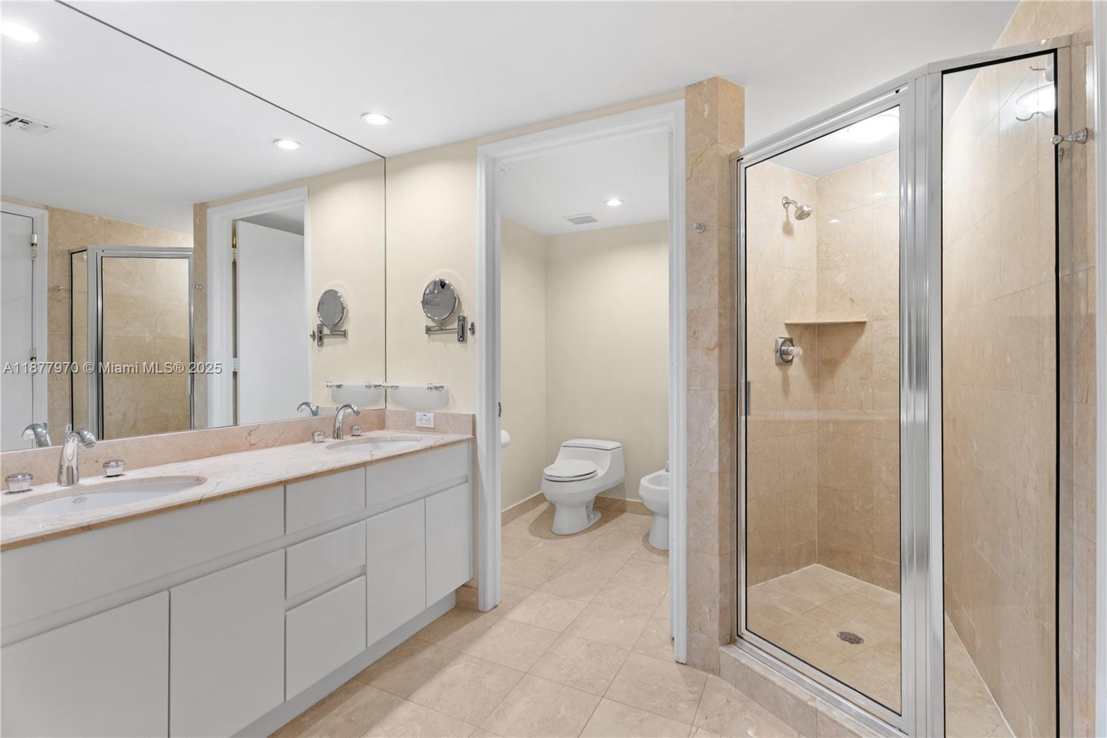 848 Brickell Key Drive, Unit 2502 Miami, FL 33131 - Photo 23 of 40 a bathroom with a shower sink and mirror