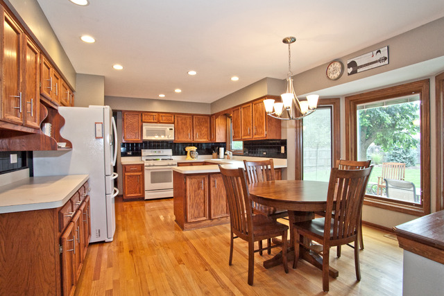 1936 Slippery Rock Road Naperville, IL 60565 - Photo 6 of 25 a kitchen with stainless steel appliances granite countertop a refrigerator a microwave oven a dining table and chairs with wooden floor