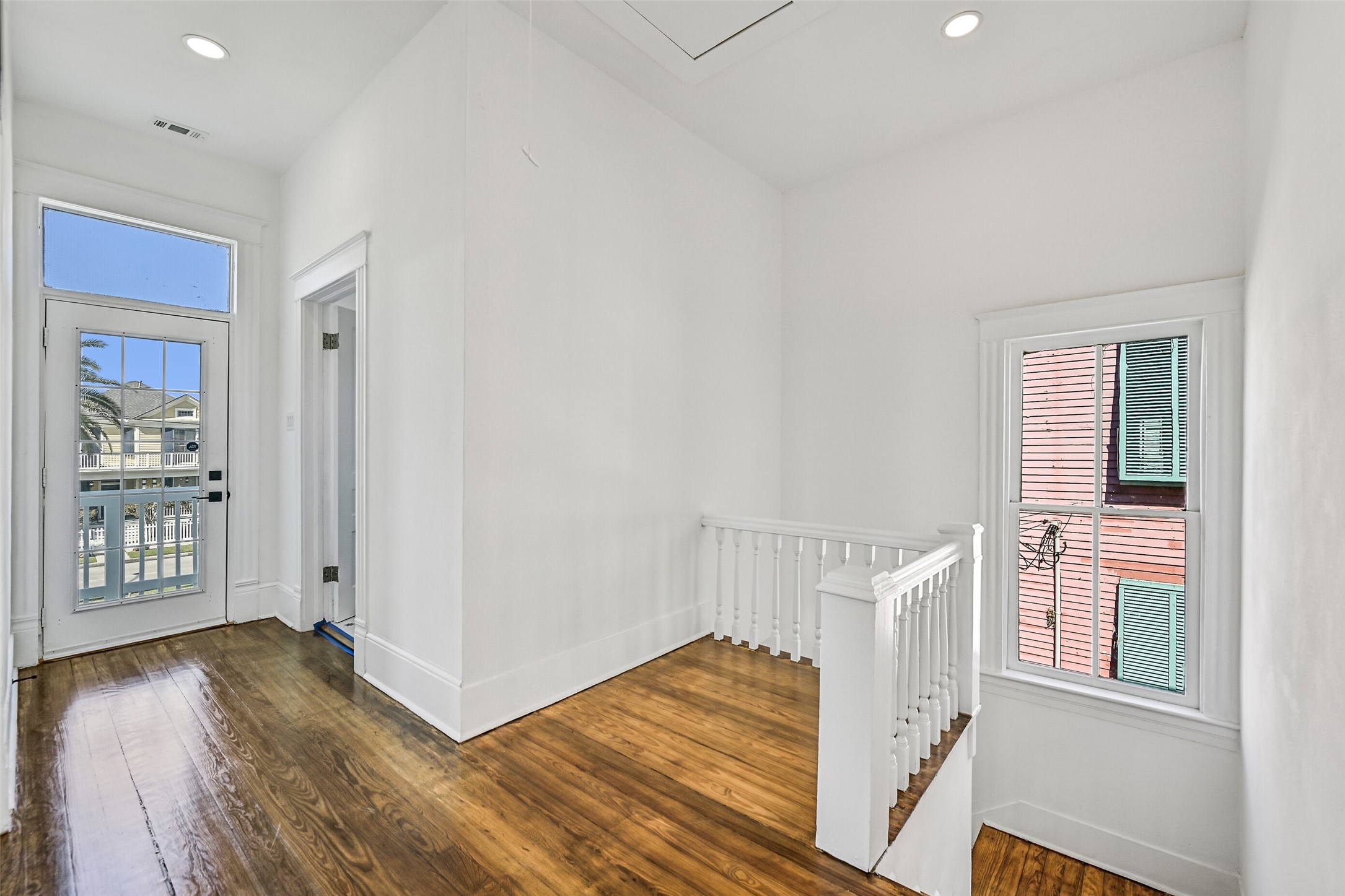2010 Rosenberg Street Galveston, TX 77550 - Photo 22 of 50 Bright and airy, this upstairs hallway connects the bedrooms, balcony, and bath with effortless flow! Sunlight highlights gleaming hardwood floors as coastal breezes drift through — a cheerful space that ties the upper level together in perfect harmony, making every step feel connected to the heart of the home.