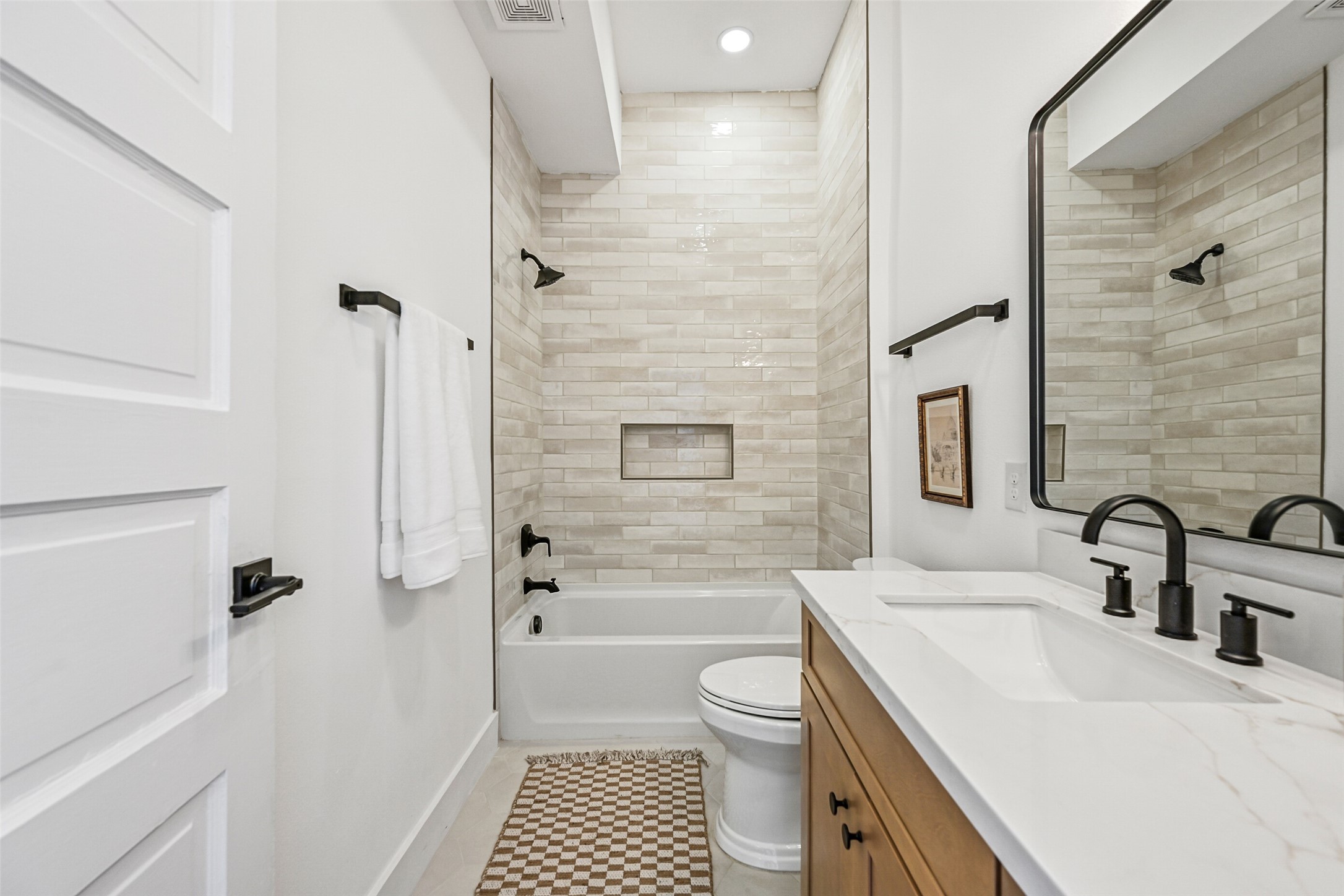 2010 Rosenberg Street Galveston, TX 77550 - Photo 26 of 50 Step into comfort and style! This fully remodeled ensuite bath features a shower-and-tub combo with gorgeous tilework, a wide vanity with ample storage, and warm lighting that creates an inviting glow. Every detail is thoughtfully designed for function and relaxation — a private retreat within your home.