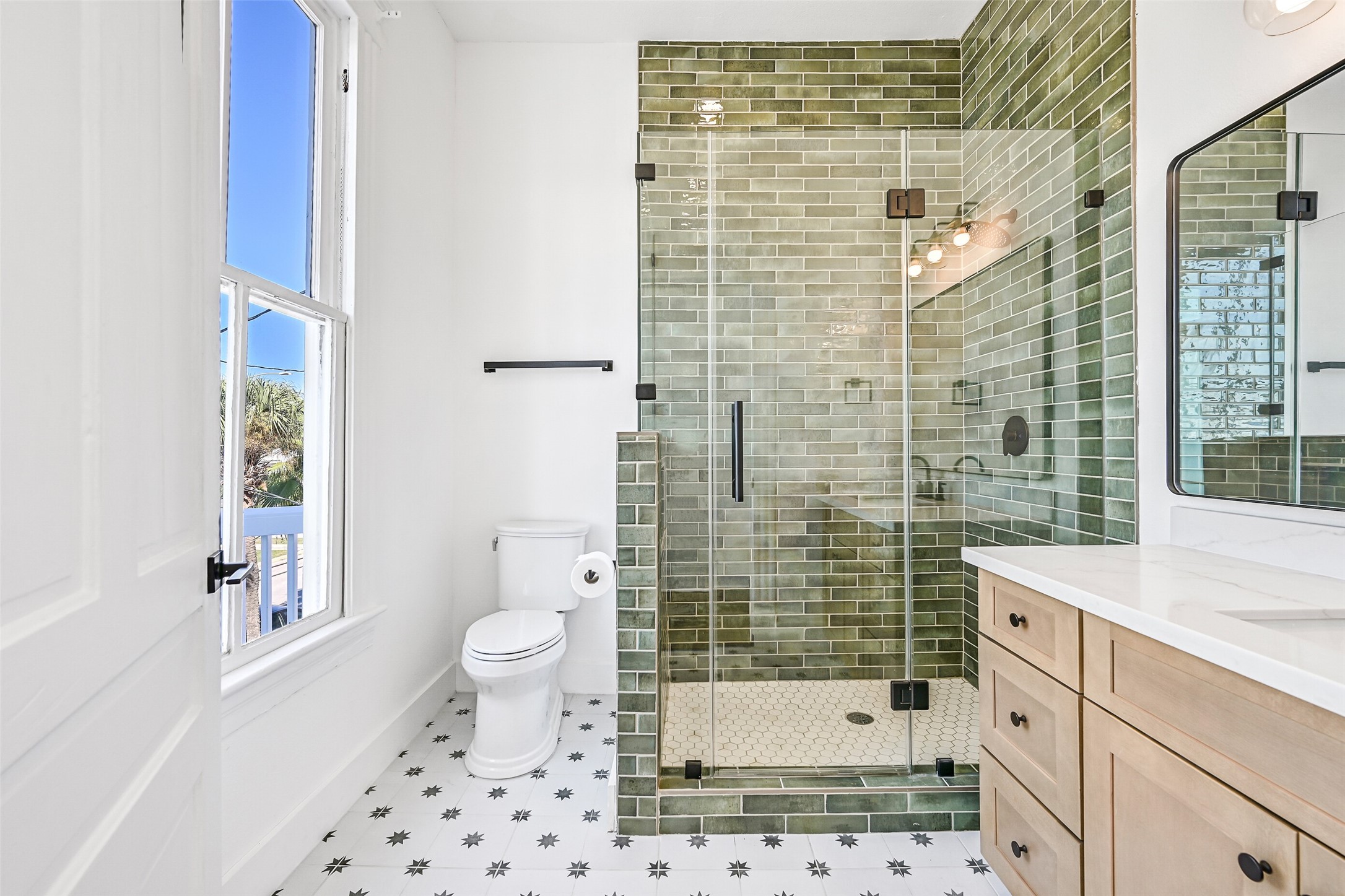 2010 Rosenberg Street Galveston, TX 77550 - Photo 29 of 50 Fresh, polished, and perfectly placed between Bedrooms #2 and #3, this full bathroom features a large enclosed shower, vanity with ample storage, and bright lighting that makes mornings a delight. Sleek, remodeled finishes and neutral tones create a clean, spa-like feel — ideal for family or guests.