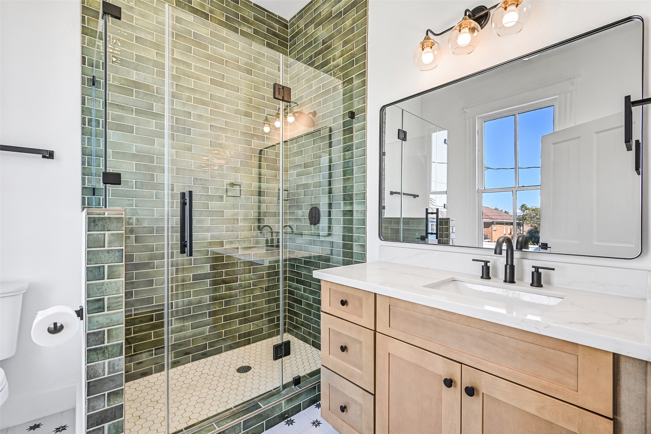 2010 Rosenberg Street Galveston, TX 77550 - Photo 3 of 50 From this angle, the spacious vanity takes center stage — perfect for morning routines or evening refreshes. The enclosed shower offers both privacy and style, while the thoughtful layout ensures easy access from both bedrooms. A beautiful blend of comfort, practicality, and timeless appeal!