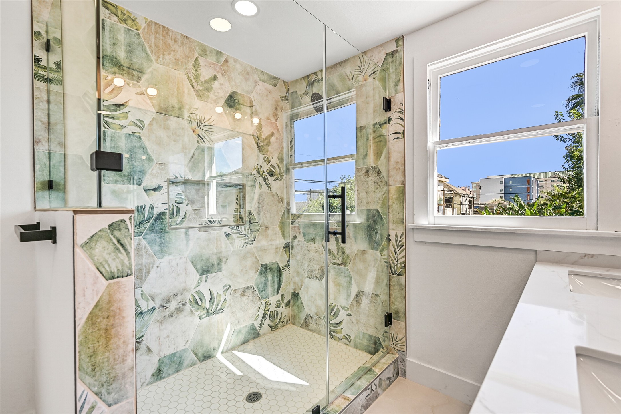 2010 Rosenberg Street Galveston, TX 77550 - Photo 35 of 50 Step into spa-level serenity! The fully enclosed shower features sleek glass doors, polished tile, and bright lighting that makes every detail shine. Spacious and refreshing, it transforms daily routines into mini getaways — perfect for a rejuvenating start to your morning or a soothing retreat after a day in the sun. Every element whispers relaxation, refinement, and island elegance.