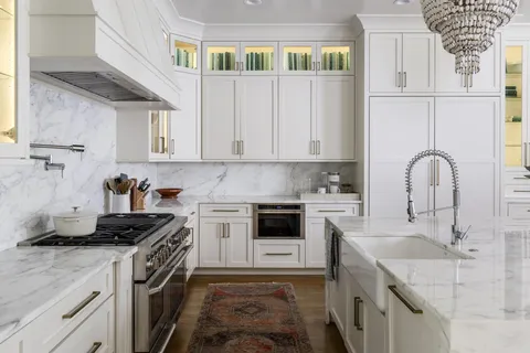 a bedroom with a bed couch and large windows