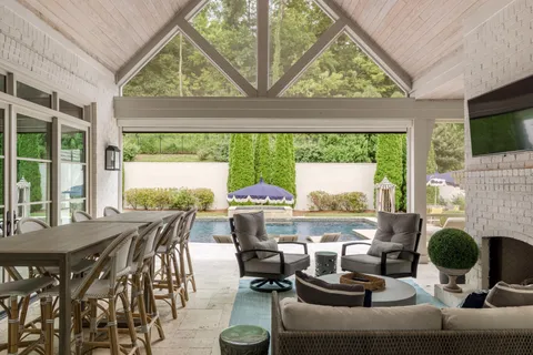 an aerial view of a house with outdoor space and trees all around