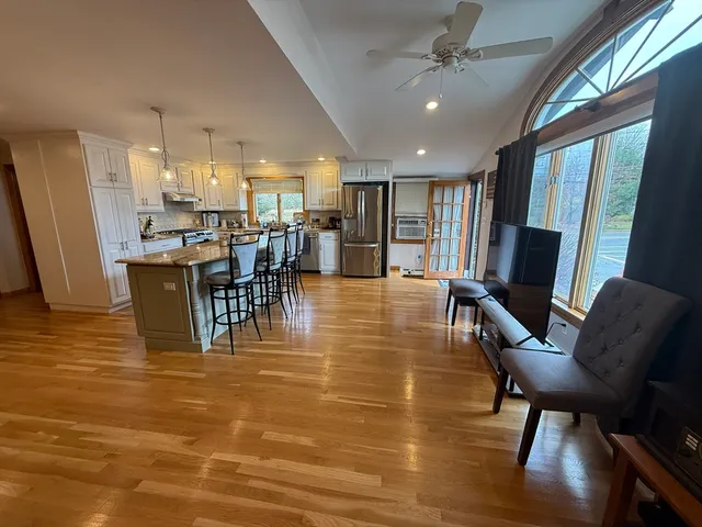 a dining room with furniture a chandelier and wooden floor