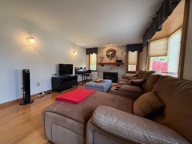 a living room with furniture pool table wooden floor and a flat screen tv