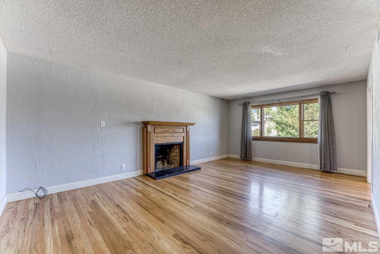 1850 Marlette Avenue Reno, NV 89503 - Photo 10 of 25 an empty room with wooden floor a fireplace and windows