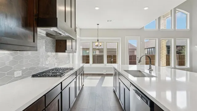a kitchen with stainless steel appliances granite countertop a sink and a refrigerator
