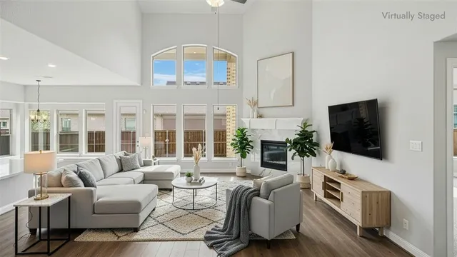 an empty room with wooden floor fireplace and windows