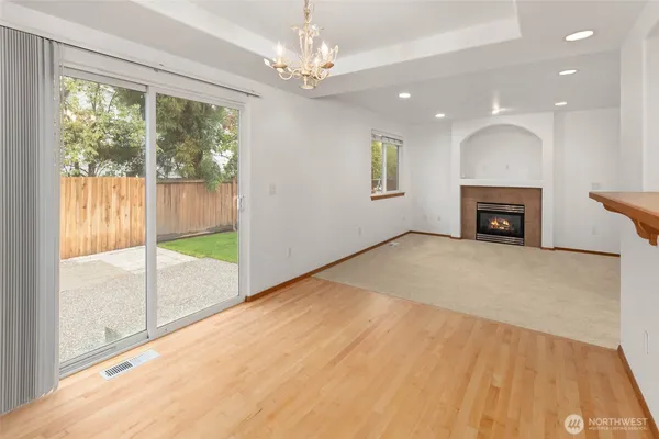 a view of an empty room with a window and a fireplace