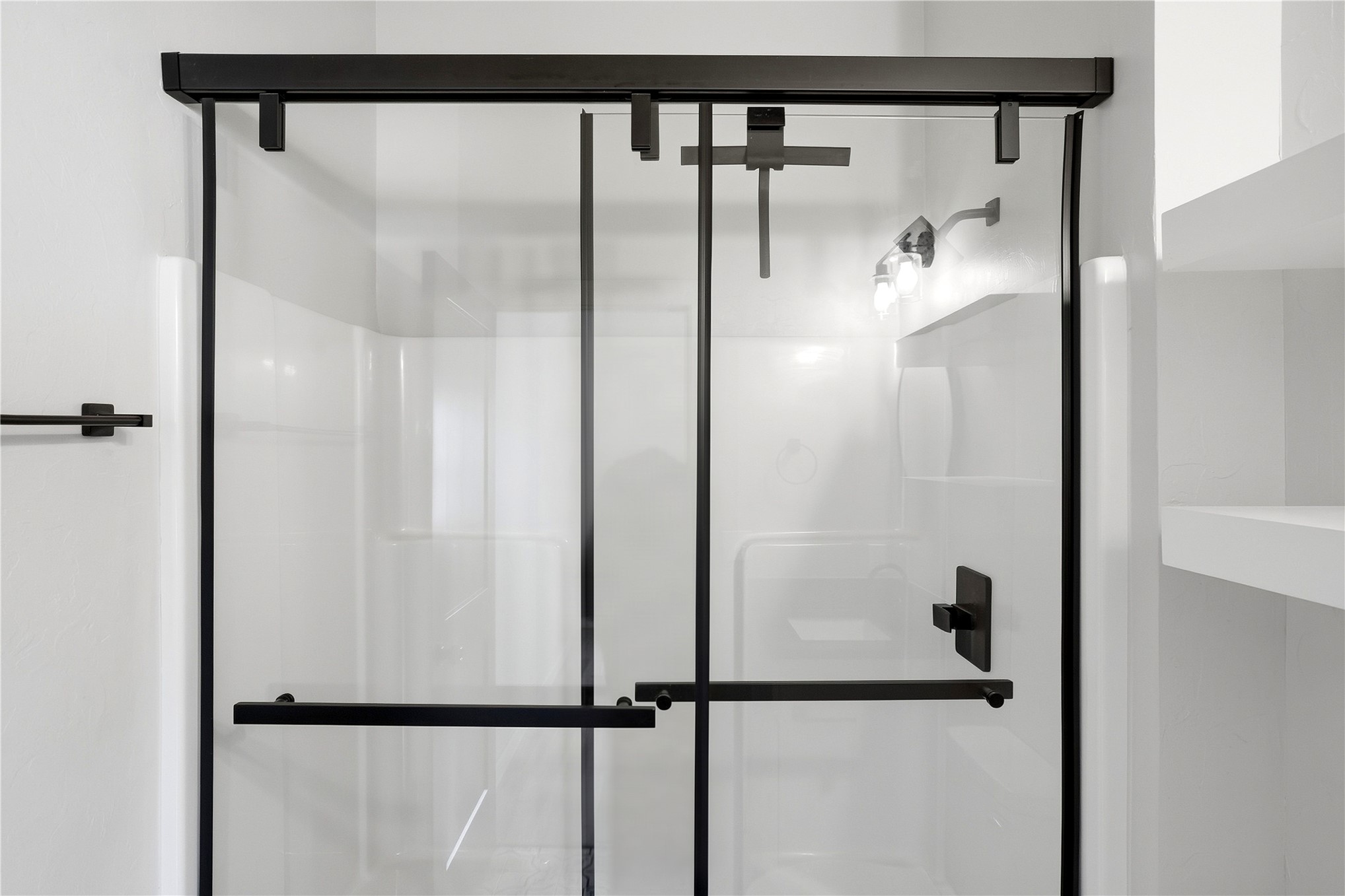 420942 East 1168 Road Eufaula, OK 74432 - Photo 26 of 43 Shower enclosure with black-framed sliding glass doors, matte black fixtures, and integrated shelving, floating shelves and tiled floors.