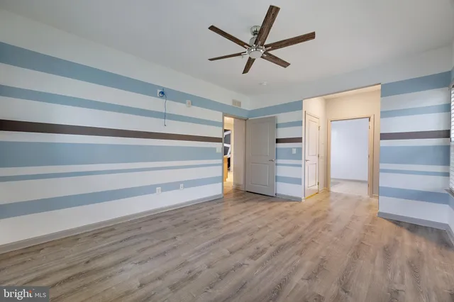 a view of a room with wooden floor and ceiling fan