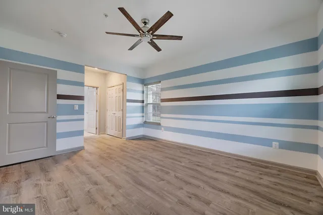a view of a livingroom with a hardwood floor and ceiling fan