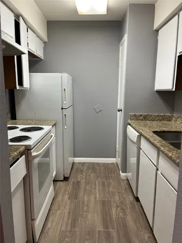 a kitchen with a white stove top oven and sink
