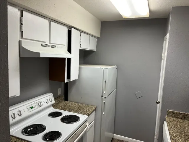 a kitchen with a refrigerator and a stove