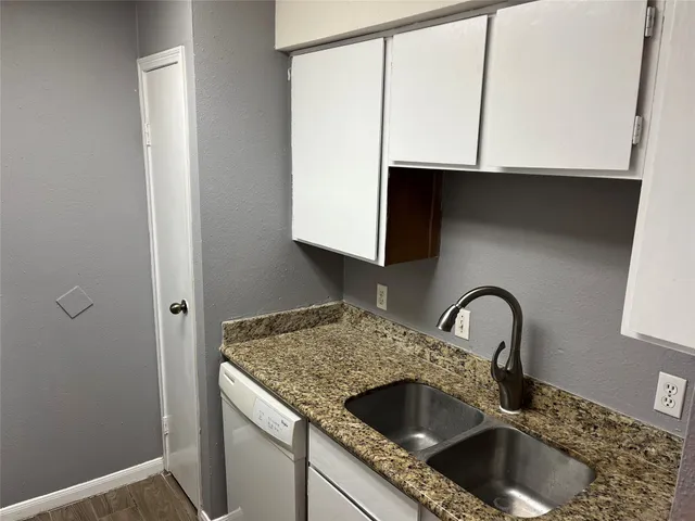 a kitchen with granite countertop a sink and a stove top oven