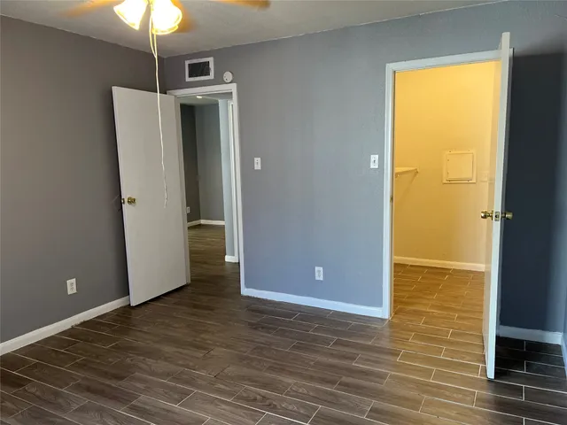 a view of a livingroom with wooden floor and a ceiling fan
