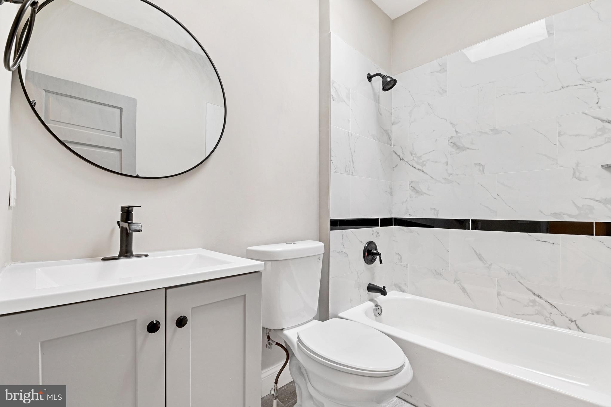 2828 Lake Avenue Baltimore, MD 21213 - Photo 14 of 28 a bathroom with a sink a toilet and a mirror