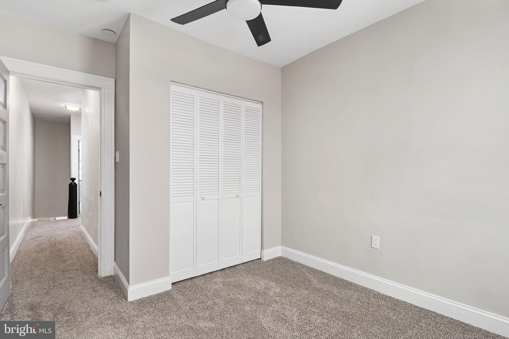 2828 Lake Avenue Baltimore, MD 21213 - Photo 17 of 28 an empty room with a ceiling fan and carpet